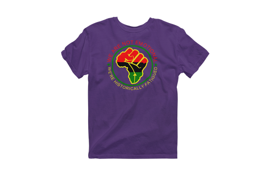 Purple short-sleeve t-shirt featuring a circular design with a raised fist symbol in Pan-African colors (red, black, green). The fist is surrounded by a green circle, and the text 'WE ARE NOT EMOTIONAL WE'RE HISTORICALLY FATIGUED' is written around it in red, yellow, and green.
