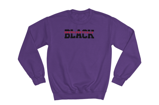 Purple crewneck sweatshirt with the text 'UNAPOLOGETICALLY BLACK' printed across the chest. 'UNAPOLOGETICALLY' is in small red letters, and 'BLACK' is in large, bold black letters