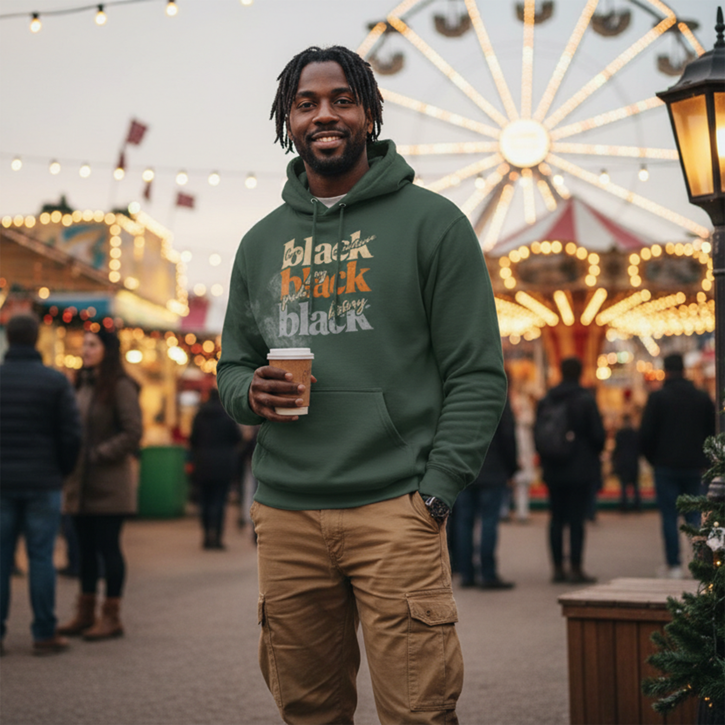 Man wearing a forest green Black Excellence, Joy, Pride and History premium hoodie
